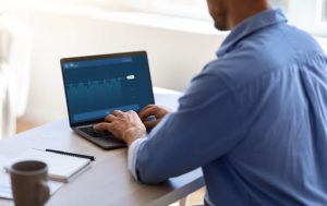 Businessman Working With Financial Analytics Or Trading Online On Laptop In Office